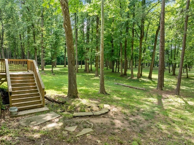 view of grassy yard with stairs and a wooden deck