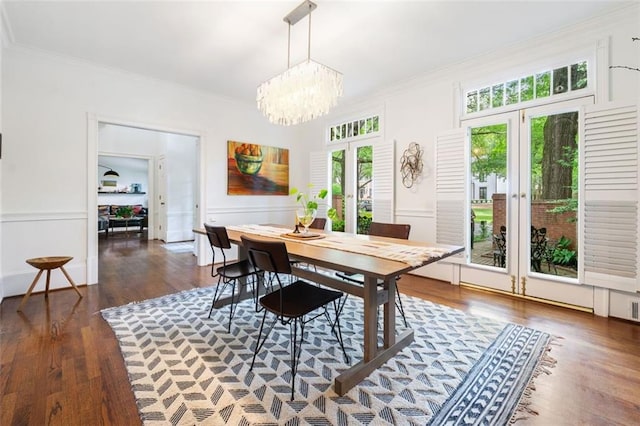dining room featuring french doors, ornamental molding, plenty of natural light, a chandelier, and wood finished floors