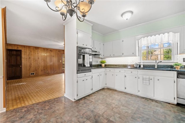 kitchen featuring sink, black oven, white cabinetry, and a chandelier