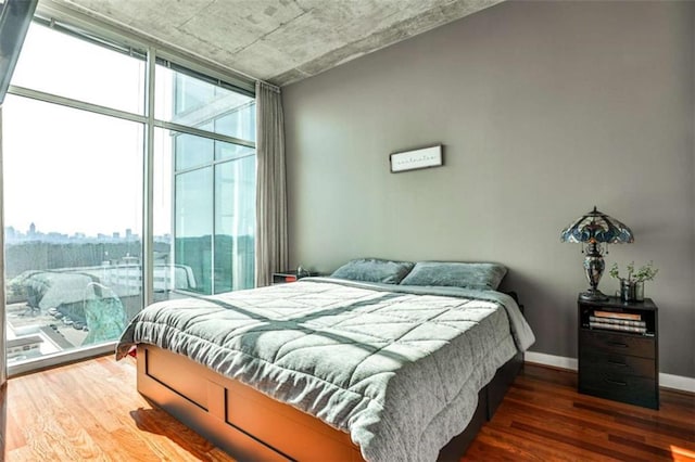 bedroom with dark wood-type flooring and a wall of windows