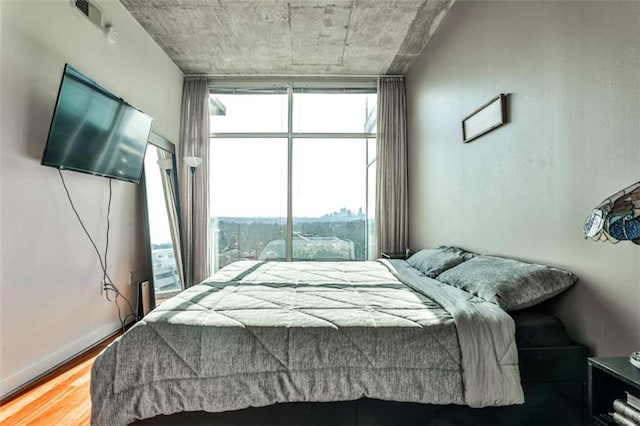 bedroom with hardwood / wood-style floors and floor to ceiling windows