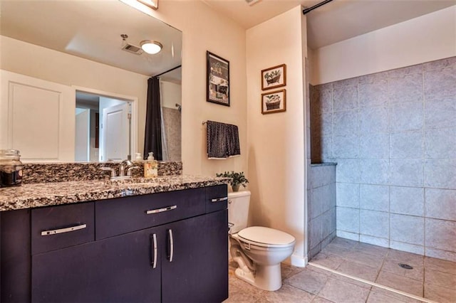 bathroom with toilet, curtained shower, tile patterned floors, and vanity