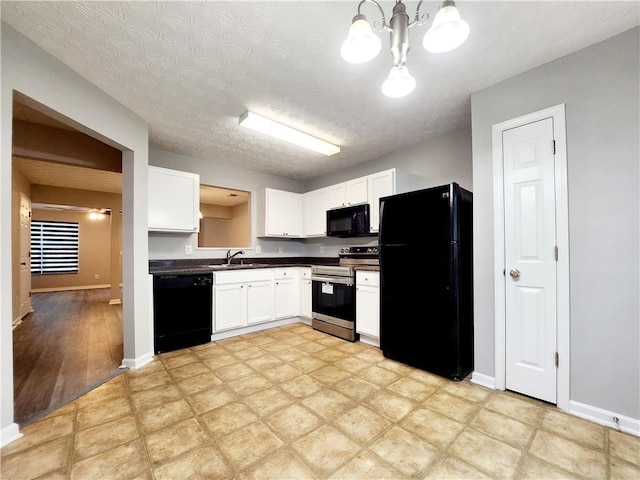 kitchen with black appliances, a sink, dark countertops, white cabinets, and baseboards