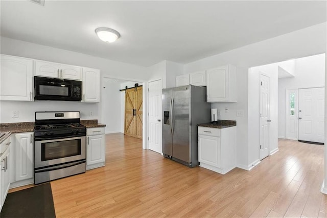 150 Crestworth Xing, Powder Springs, GA 30127 - kitchen featuring stainless steel appliances, white cabinetry, a barn door, and light wood-style floors