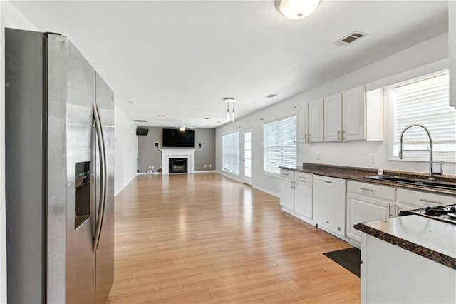 150 Crestworth Xing, Powder Springs, GA 30127 - kitchen featuring stainless steel refrigerator with ice dispenser, dishwasher, dark countertops, white cabinetry, and light wood-style floors