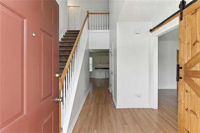150 Crestworth Xing, Powder Springs, GA 30127 - foyer entrance featuring a barn door, light wood-type flooring, and stairs