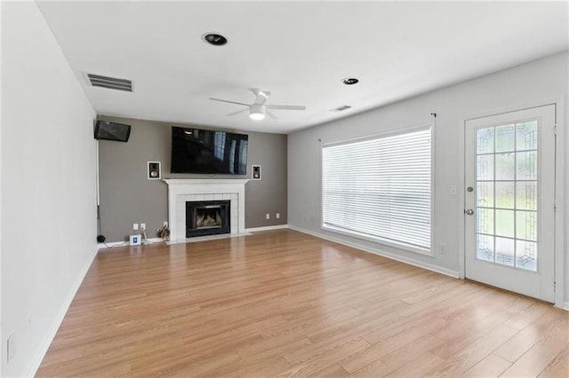 150 Crestworth Xing, Powder Springs, GA 30127 - unfurnished living room with ceiling fan, light wood finished floors, and a fireplace