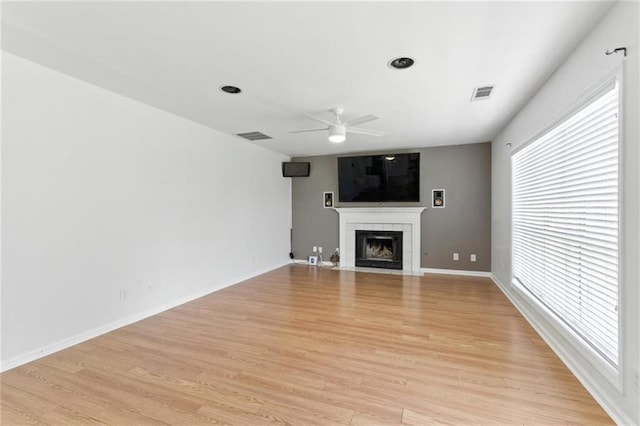 150 Crestworth Xing, Powder Springs, GA 30127 - unfurnished living room featuring ceiling fan, a tiled fireplace, and light wood finished floors