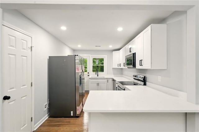 163 Oakcliff Ct, South Fulton, GA 30331 - kitchen featuring appliances with stainless steel finishes, a sink, a peninsula, wood finished floors, and light countertops