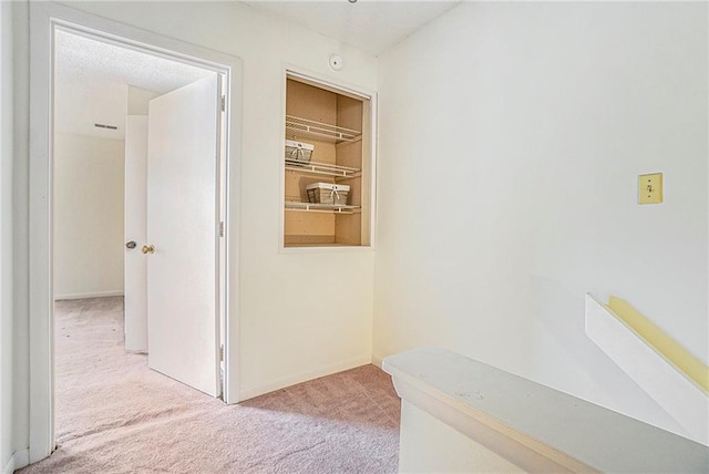 corridor with light carpet and baseboards