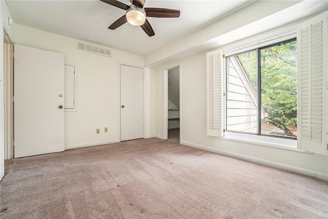 unfurnished bedroom featuring light carpet, baseboards, multiple windows, and visible vents