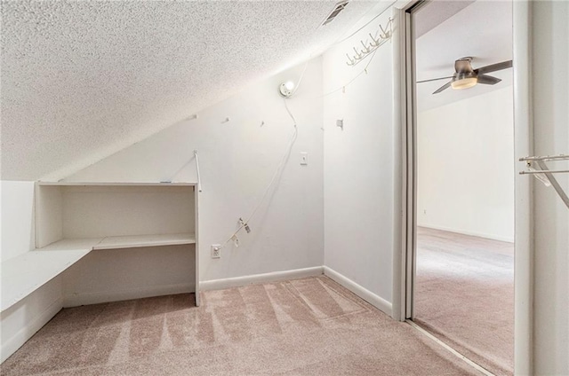 bonus room featuring ceiling fan, a textured ceiling, carpet flooring, baseboards, and vaulted ceiling