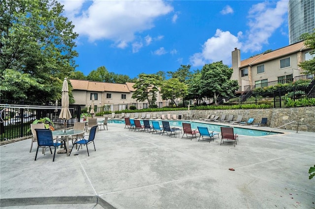 pool with a patio area and fence