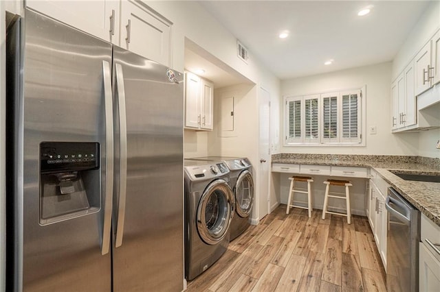 laundry area featuring recessed lighting, visible vents, light wood-style floors, a sink, and separate washer and dryer