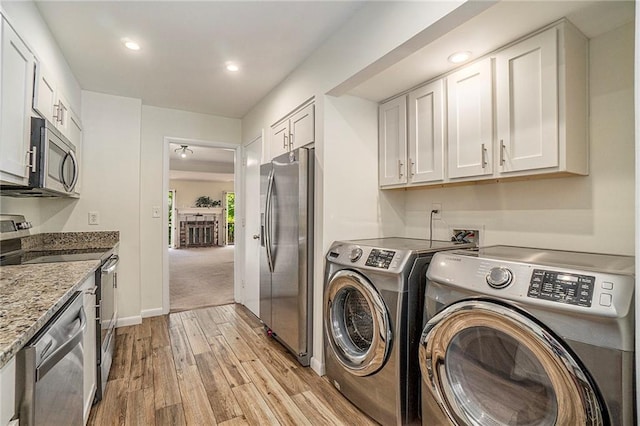 laundry room featuring recessed lighting, laundry area, baseboards, washer and dryer, and light wood-type flooring