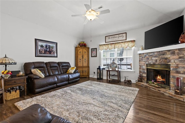 living area with a ceiling fan, a stone fireplace, visible vents, and wood finished floors