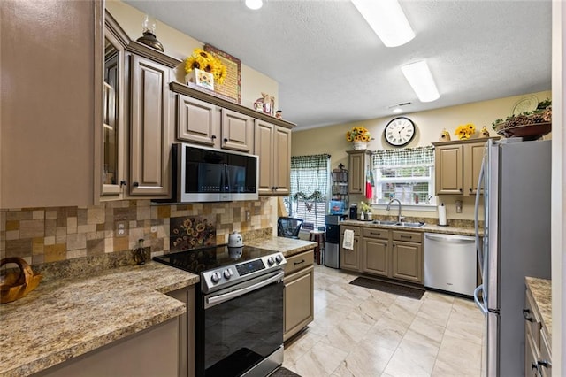 kitchen featuring a sink, tasteful backsplash, marble finish floor, a textured ceiling, and appliances with stainless steel finishes