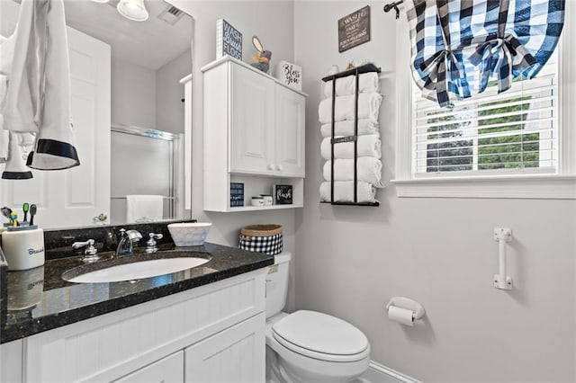 bathroom featuring a stall shower, vanity, toilet, and visible vents