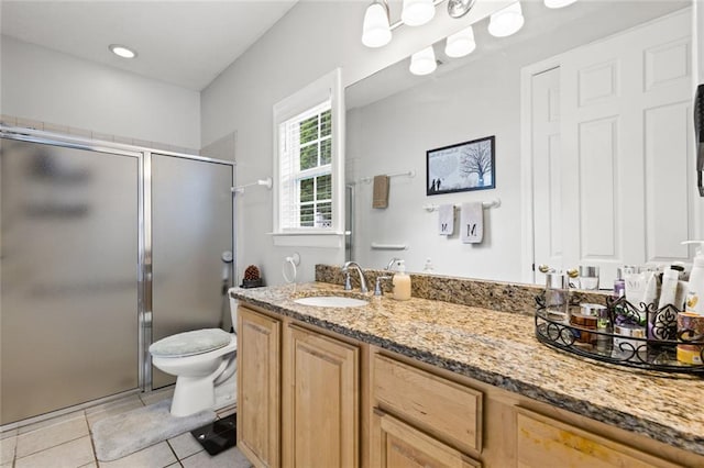 bathroom featuring tile patterned floors, vanity, toilet, and a shower stall