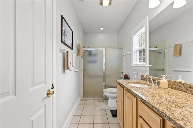 bathroom featuring toilet, a stall shower, baseboards, tile patterned flooring, and vanity