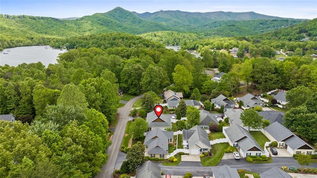 aerial view with a water and mountain view, a forest view, and a residential view