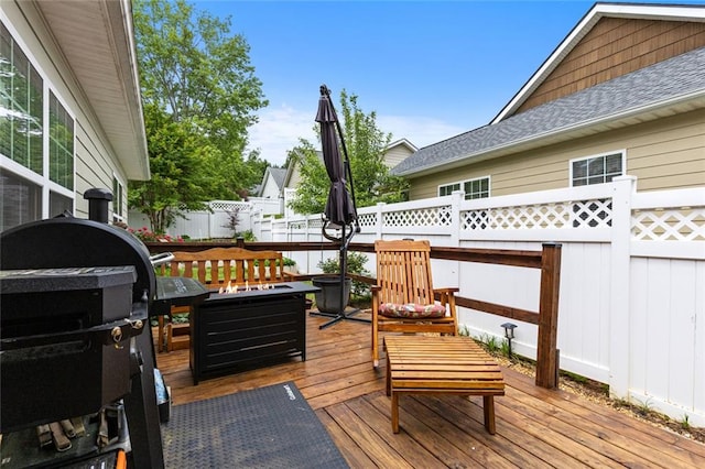 wooden terrace with a fenced backyard
