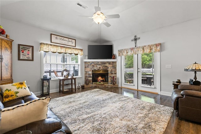 living room with a ceiling fan, baseboards, a fireplace, and visible vents