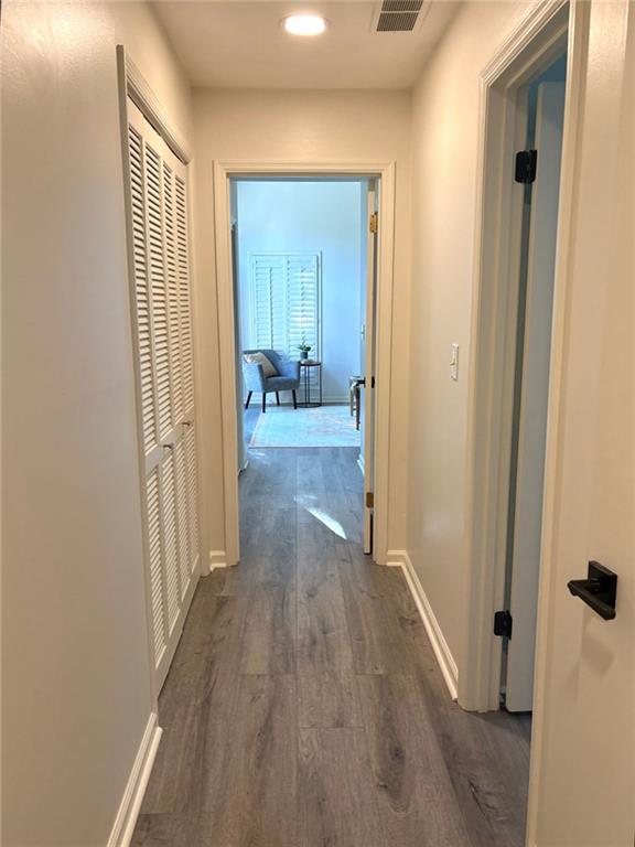 hall with recessed lighting, baseboards, dark wood-style floors, and visible vents
