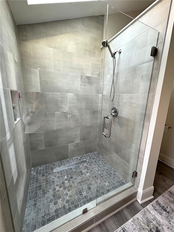 bathroom with a stall shower and wood finished floors