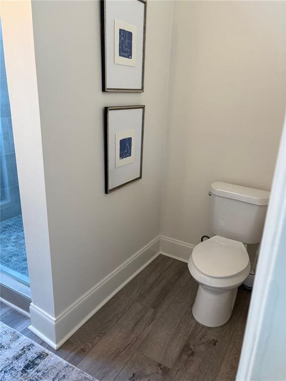 bathroom featuring toilet, baseboards, and wood finished floors