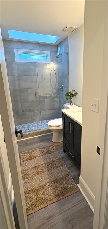 full bath featuring visible vents, a stall shower, wood finished floors, vanity, and toilet