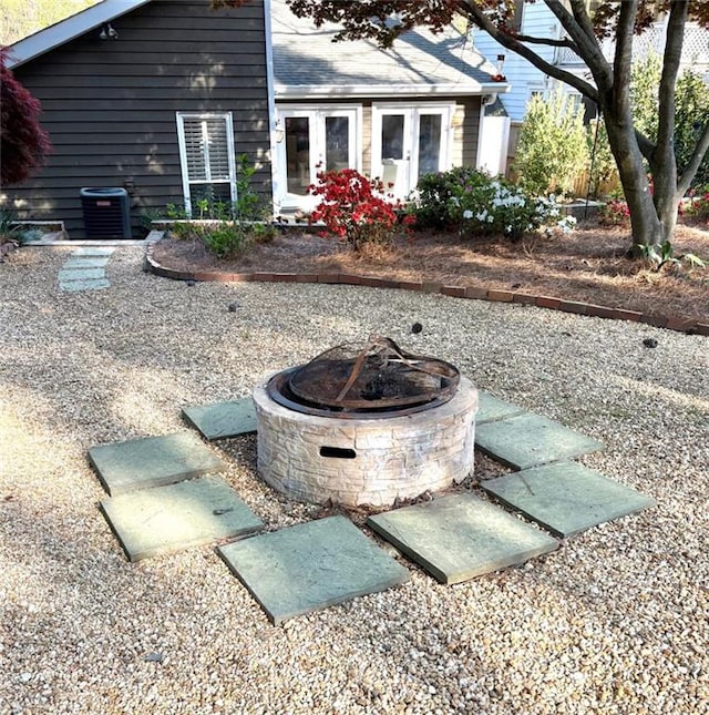 view of yard with french doors, a fire pit, and central AC