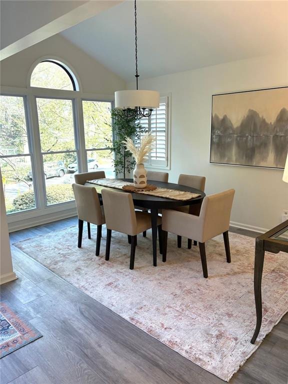 dining area with baseboards, lofted ceiling, and wood finished floors