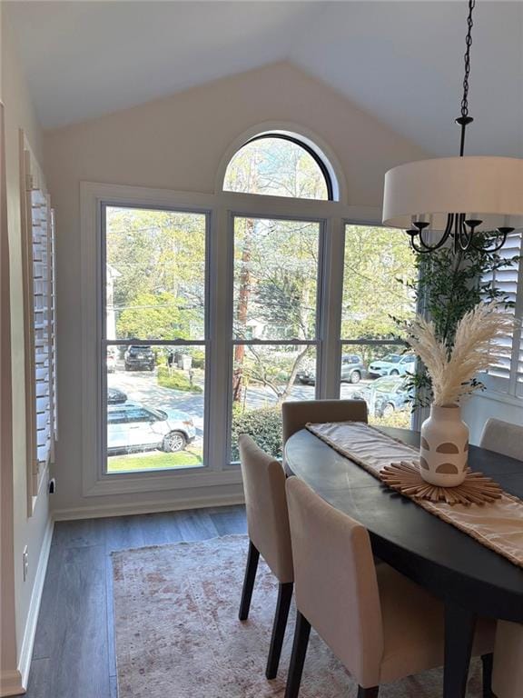 dining room featuring baseboards, wood finished floors, and lofted ceiling