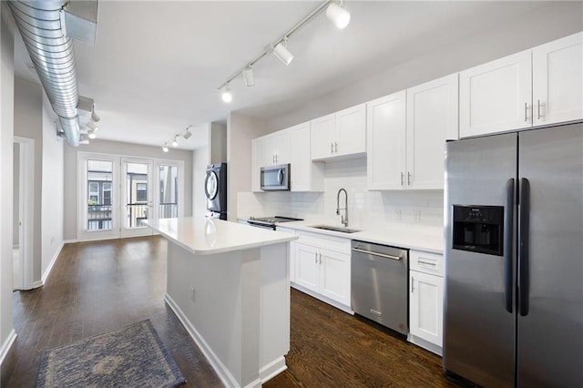 5300 Peachtree Rd Unit 3207, Chamblee, GA 30341 - kitchen featuring stainless steel appliances, rail lighting, tasteful backsplash, white cabinets, and light countertops