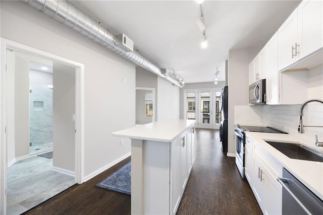 5300 Peachtree Rd Unit 3207, Chamblee, GA 30341 - kitchen featuring appliances with stainless steel finishes, a center island, light countertops, dark wood-style flooring, and white cabinetry
