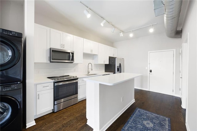 5300 Peachtree Rd Unit 3207, Chamblee, GA 30341 - kitchen featuring appliances with stainless steel finishes, stacked washer and clothes dryer, light countertops, and dark wood finished floors