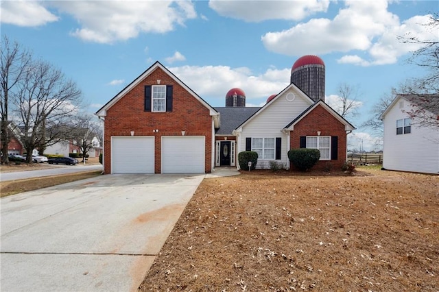 traditional-style house with brick siding, driveway, an attached garage, and fence