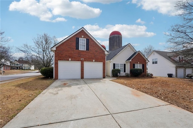 traditional-style home featuring a garage, concrete driveway, and brick siding