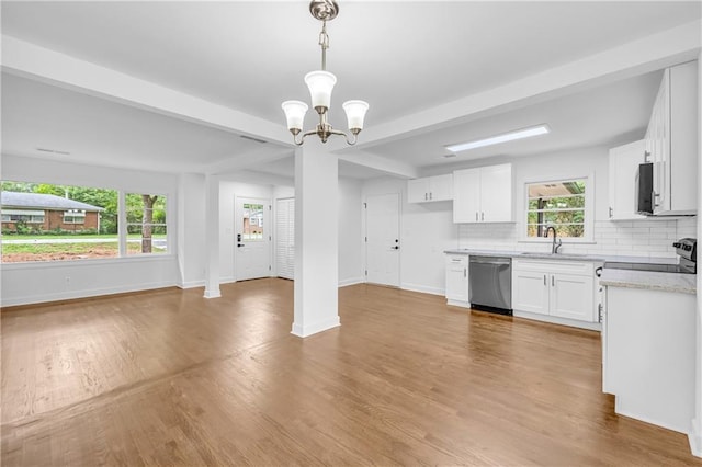 kitchen with pendant lighting, light hardwood / wood-style flooring, backsplash, white cabinets, and appliances with stainless steel finishes