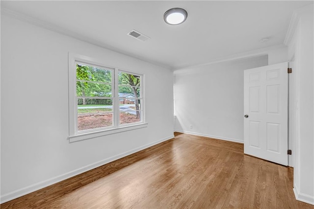 empty room with light wood-type flooring and ornamental molding