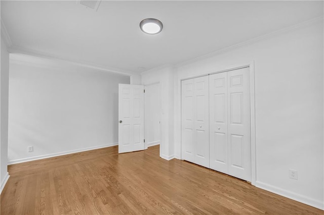 unfurnished bedroom featuring a closet, light hardwood / wood-style flooring, and ornamental molding