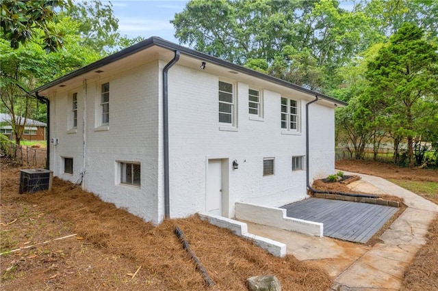 rear view of house with central AC unit and a patio