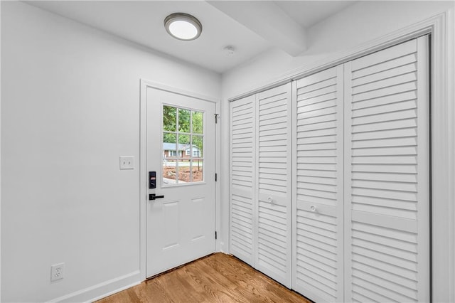 entryway featuring light wood-type flooring and beam ceiling