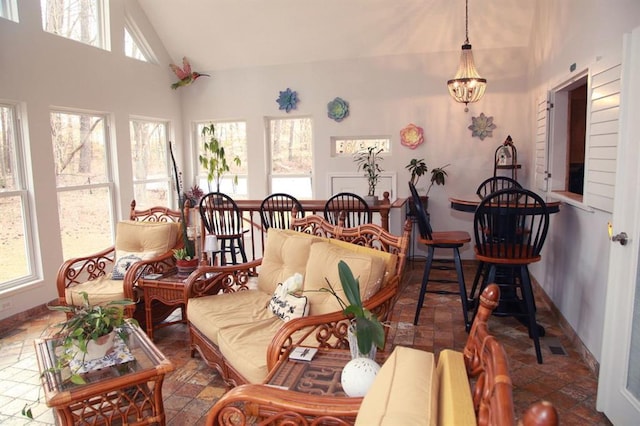 sunroom featuring vaulted ceiling and an inviting chandelier