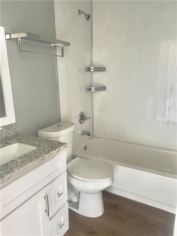 full bathroom featuring vanity, hardwood / wood-style flooring, toilet, and tiled shower / bath