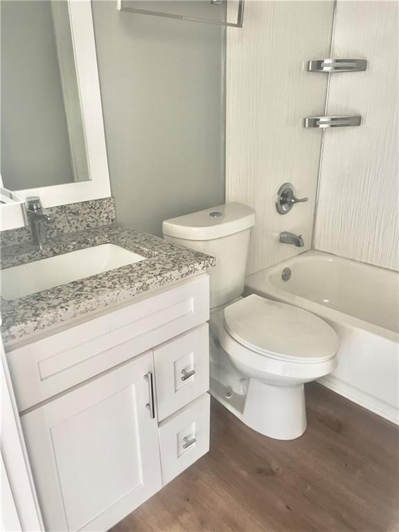 full bathroom with vanity, hardwood / wood-style flooring, tub / shower combination, and toilet