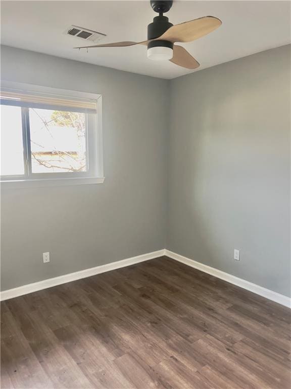 empty room featuring dark wood-type flooring and ceiling fan