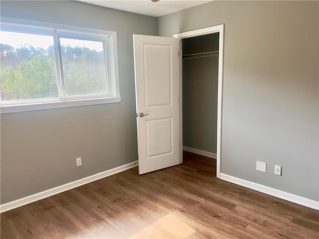 unfurnished bedroom with hardwood / wood-style floors and a closet