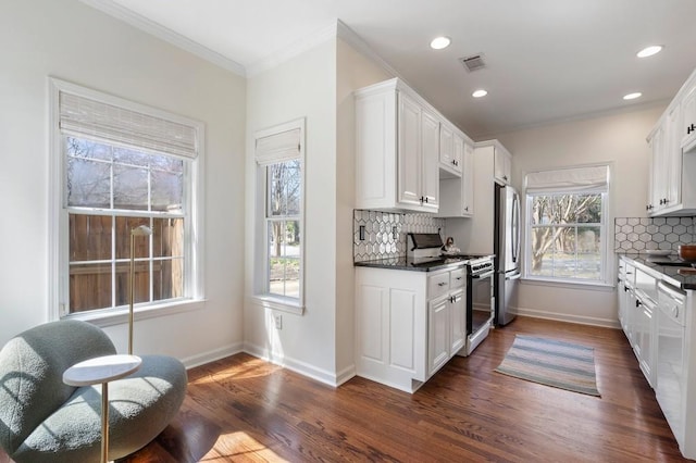 kitchen with visible vents, dark wood-type flooring, dishwasher, range with gas stovetop, and freestanding refrigerator